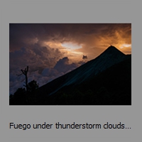 Fuego under thunderstorm clouds at sunset